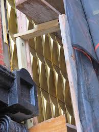 Brass rainscreen on stainless steel rails