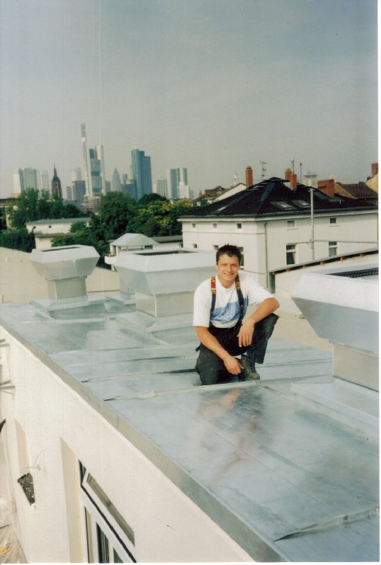 Erno posing on a fully seamed stainless steel roof in Germany
