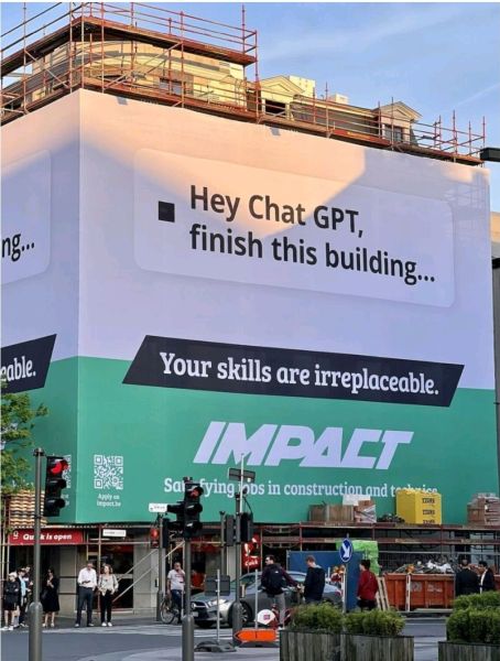 A sign on a building that reads, "Hey ChatGPT, finish this building... Your skills are irreplaceable," emphasizing the value of skilled trades in the construction industry