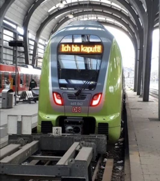 Train displaying sign reading 'Ich bin kaputt' as a humorous reminder of the importance of durable engineering in metal roofing solutions by Spengler Industries.