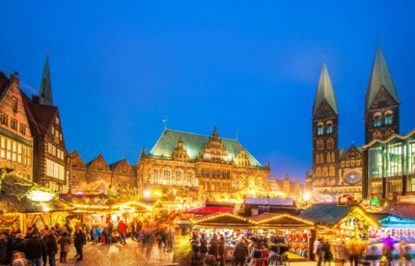 A festive scene at the Bremen Christmas Market in Germany, showcasing elegant copper roofs and spires against a backdrop of holiday lights and decorations
