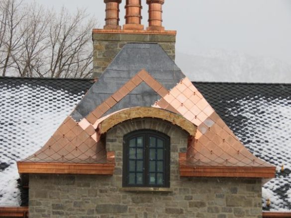 Close-up view of fully seamed copper details on a radius roof, showcasing seamless round valleys, convex and concave curves, and a slight bell curve for a stunning architectural finish.